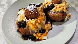 A plate of dessert with fruit and powdered sugar. - Casa Magica (Bușteni)