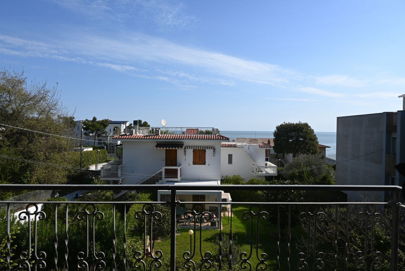 Ein Wohngebiet mit Häusern, einer Satellitenschüssel und freiem Blick auf das Meer.