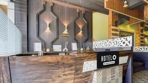 Un comptoir d'accueil avec une enseigne indiquant « HÔTEL », une autre indiquant « RÉCEPTION » et une étiquette indiquant « Service aux entreprises ».