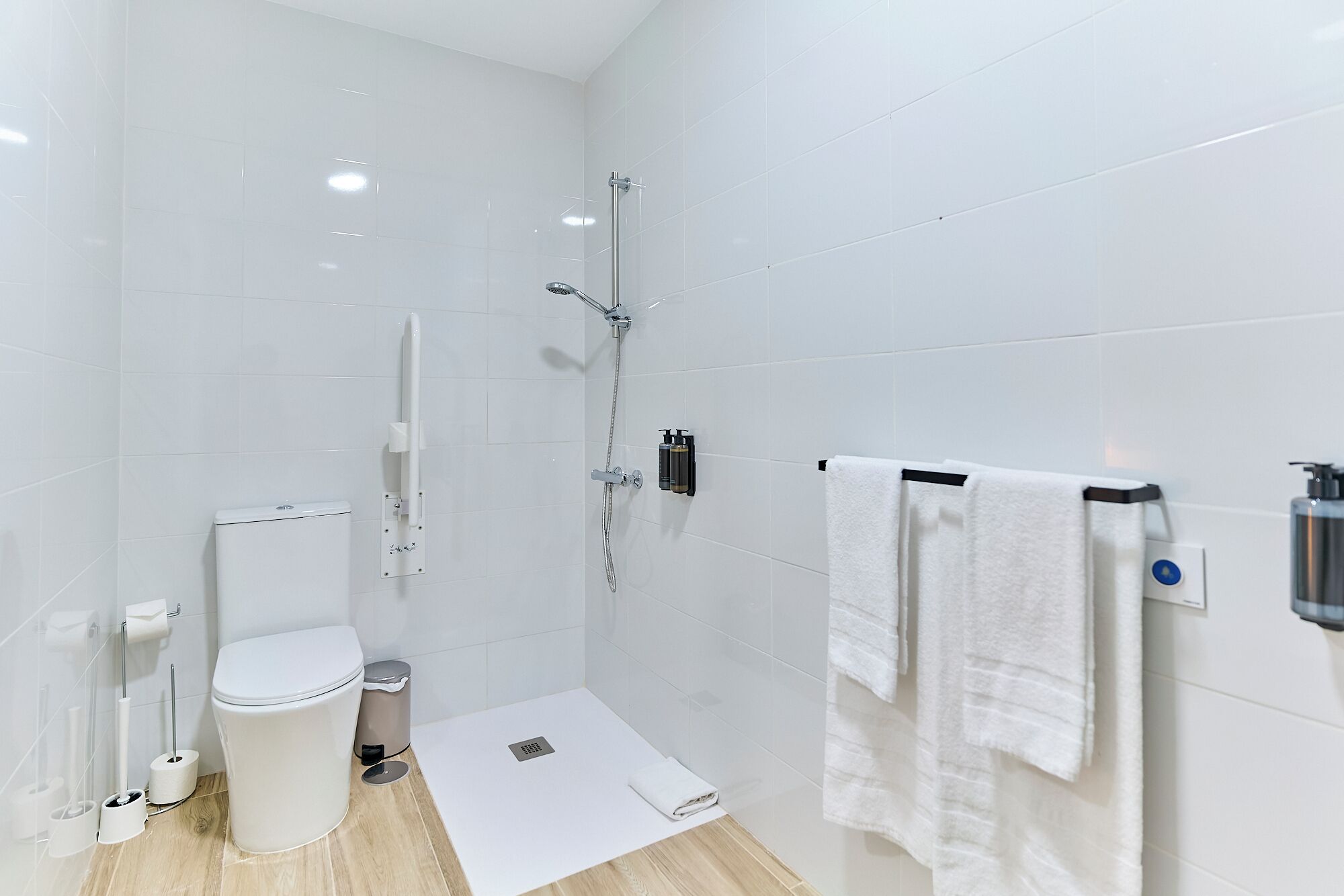 Un baño moderno con inodoro, bidé, ducha y perchero para toallas.