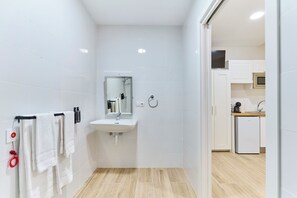 A modern bathroom with a sink, mirror, and towel rack. - Apartamentos Méndez Álvaro by gaiarooms (Madrid)