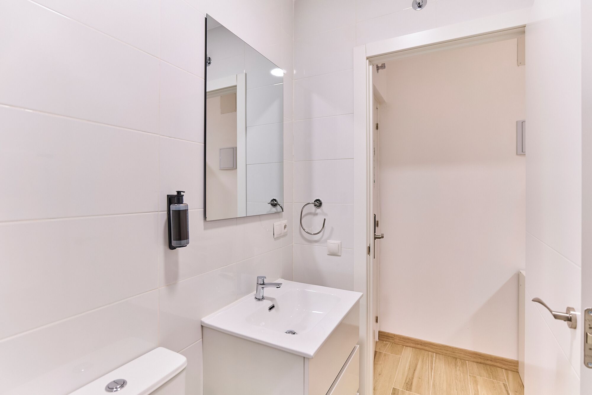 Ein modernes Badezimmer mit Waschbecken, Spiegel und Toilette.