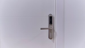 A modern door with a digital lock and a keyhole.