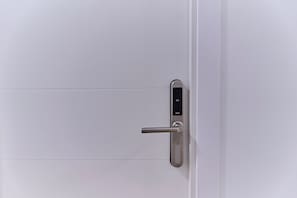 A modern door with a digital lock and a keyhole.
