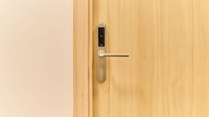 Uma porta de madeira com fechadura eletrônica moderna e fechadura para chave.