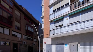 Um edifício de vários andares com fachada de tijolos, entrada com portão e céu claro.