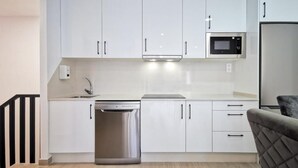 A modern kitchen with white cabinets, a stainless steel dishwasher, a microwave, and a built-in oven. - Apartamentos Costa de Foz by gaiarooms  (Foz)
