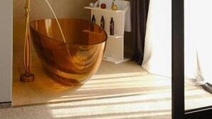 A modern bathroom with a large copper basin, a white shelf with toiletries, and a view of the outdoors through a window with curtains. - Hotel Meteo Kakheti (Telavi)