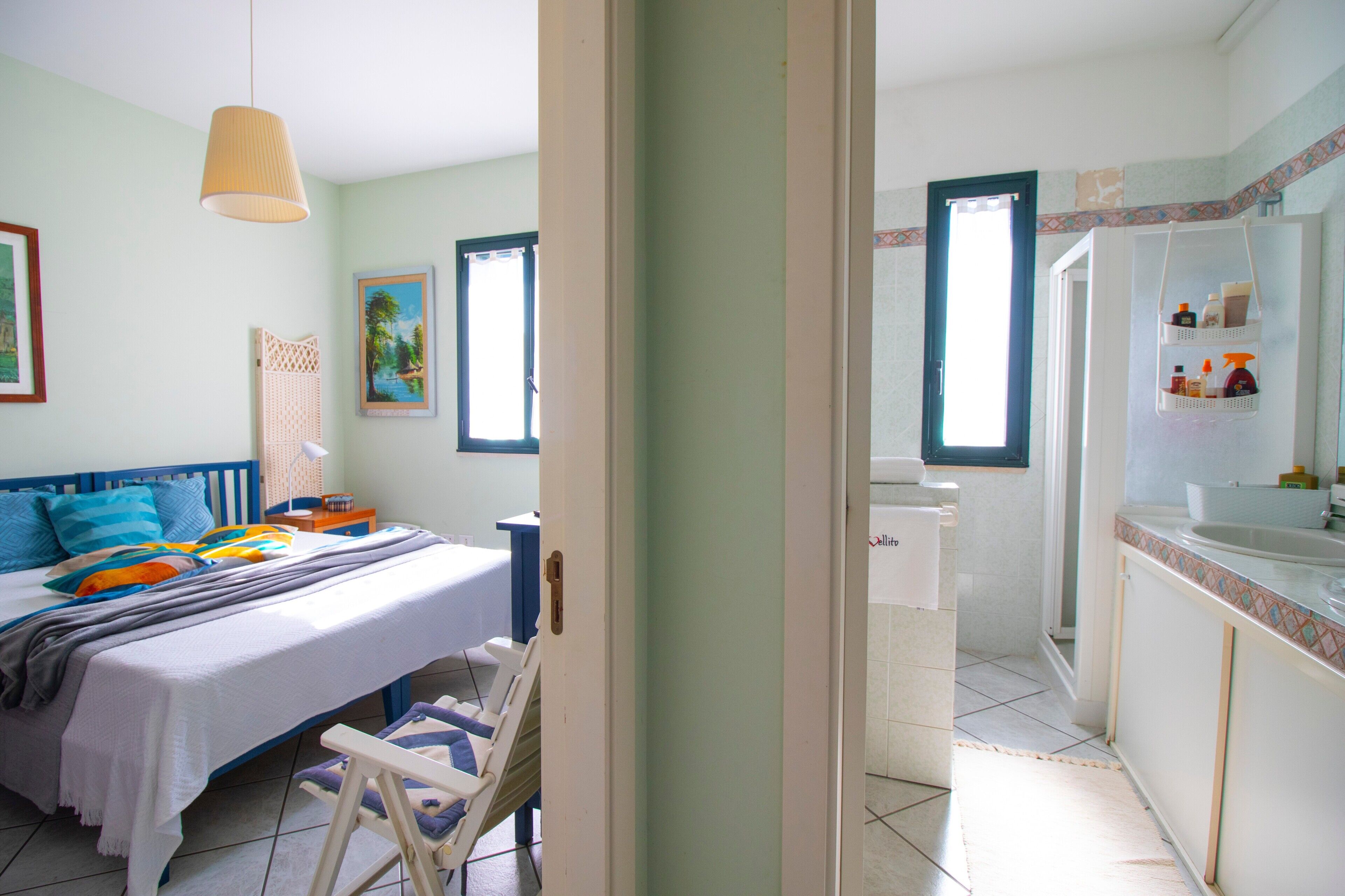 A bedroom with a bed, bedside table, and a window.