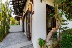 A building with a stone pathway leading to a door, a number sign '301', and a tree growing on the wall. - Ancient Retreat Hoi An (Hoi An Dong)