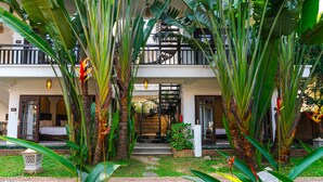A hotel with a two-story structure, a balcony, and a garden with tropical plants. - Ancient Retreat Hoi An (Da Nang)
