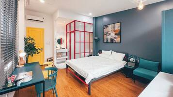 Une chambre à coucher moderne avec un lit, une table de chevet et un bureau avec une chaise.