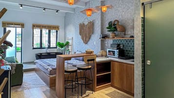 A modern kitchen with wooden cabinets, a dining area with a table and chairs, and pendant lighting.