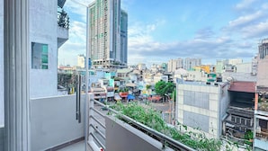 A high-rise building with a balcony overlooking a cityscape. - HHome Tran Dinh Xu (Ho Chi Minh City)