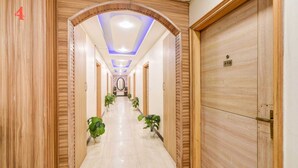 A hotel hallway with wooden paneling, a ceiling with blue lighting, and a door marked '410'. - HOTEL ROYAL RESIDENCY  (New Delhi)