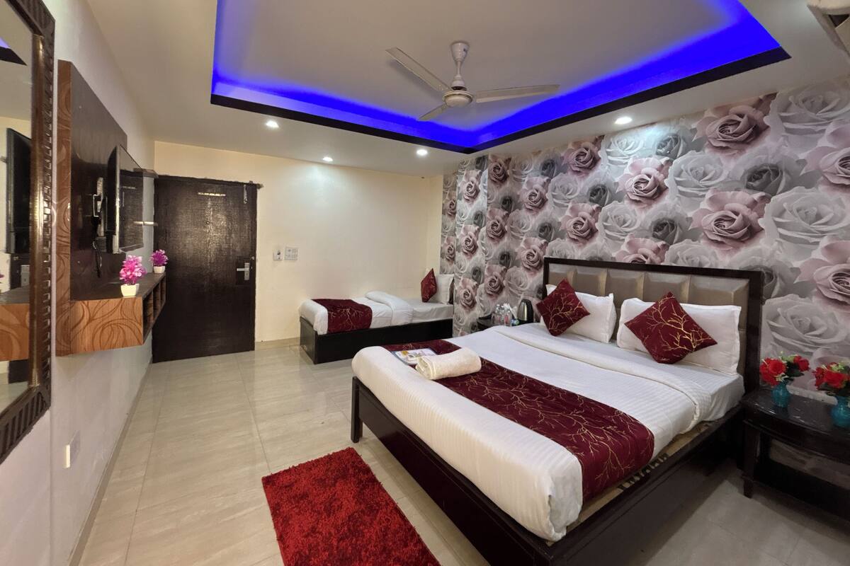 Un dormitorio moderno con cama, ventilador de techo y pared con estampado floral.