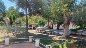 A courtyard with a barbecue area, benches, and a staircase leading to a building. - Ayres, Simple Apartment (El Vendrell)