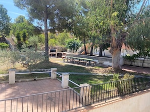 A courtyard with a barbecue area, benches, and a staircase leading to a building. - Ayres, Simple Apartment (El Vendrell)