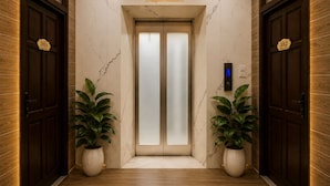 A hotel lobby with wooden paneling, marble walls, two potted plants, and a digital elevator control panel. - La Yen Homes (Ho Chi Minh City)