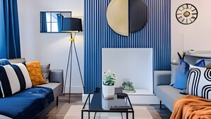 Un salon moderne avec un canapé, une table basse, une lampe et une horloge murale.