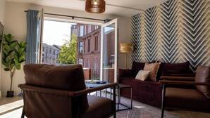 Ein modernes Wohnzimmer mit einem braunen Ledersofa, einem kleinen Tisch und einer Wand mit Muster.