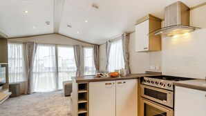 Een moderne keuken met een inbouwfornuis, oven en rvs afzuigkap.