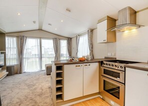 Eine moderne Küche mit Einbauherd, Backofen und Edelstahl-Dunstabzugshaube.