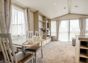 Een moderne hotelkamer met een zithoek, een televisie en een boekenkast.