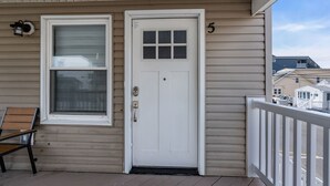 A house with a white door, a window, and a number '5' on the wall. - Charming Seaside Escape | 2BR, Parking, Beach (Seaside Heights)