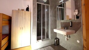 Un baño moderno con ducha, lavamanos y espejo.