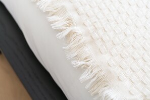 A close-up of a white textured fabric with fringe details, likely part of a bed or couch. - Relaxing 5BR Apartment Close to Downtown (Ghent)