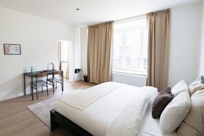 A bedroom with a bed, a desk, and a chair. - Relaxing 5BR Apartment Close to Downtown (Ghent)