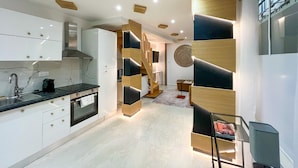 A modern kitchen with white cabinets, a black countertop, and a built-in oven. - UrbanFlat 226 - Appartement pour 6  au Centre de paris (Paris)