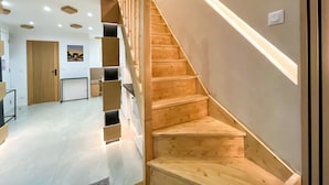 A modern interior with a wooden staircase, recessed lighting, and a minimalist design. - UrbanFlat 226 - Appartement pour 6  au Centre de paris (Paris)
