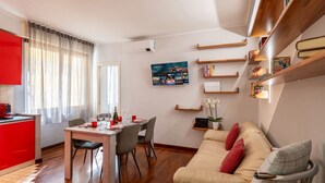 Ein modernes Wohnzimmer mit Essbereich, einer Couch und einem Bücherregal.