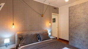Ein Schlafzimmer mit einem Bett, Nachttischlampen und einer Tür.