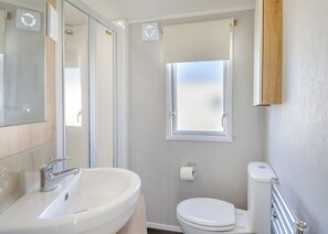 Un baño con lavamanos, inodoro y ventana.