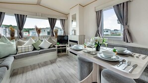 Een modern interieur met een bank, eettafel en televisie.