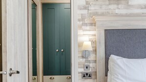 Un dormitorio con cama, mesita de noche, lámpara, armario y puerta.