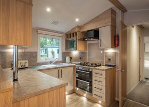 A modern kitchen with a built-in oven, a microwave, and a gas stove.