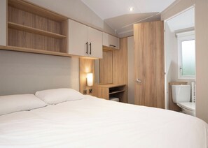 A bedroom with a bed, built-in wardrobe, and a window.