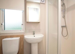 A bathroom with a toilet, sink, and shower.