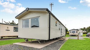 Ein Wohnmobil mit großem Fenster, Satellitenschüssel und kleiner Veranda.