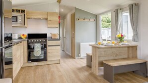 Eine moderne Küche mit Holzschränken, einem Einbauofen und einer Frühstückstheke mit Sitzbank.