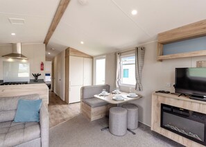 Een modern interieur van een camper, met een kitchenette, een eethoek en een woongedeelte.