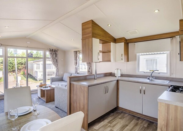 Una cocina compacta con comedor, ventanas amplias y vistas al exterior.