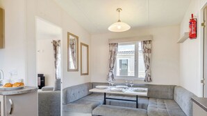A compact kitchen with a dining area, a built-in bench, and a fire extinguisher on the wall. - Gold Accessible with parking P (Walton-on-the-Naze)