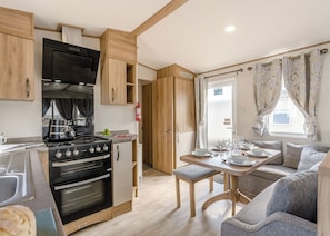 A compact kitchen with a stove, oven, and wooden cabinets. - Gold 3 Bedroom Caravan, Sleeps 8 (Ryde, Nr Bembridge)