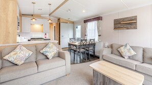 Un salon moderne comprenant un canapé, une table basse et un coin repas avec des chaises et une table.