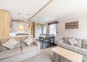 Ein modernes Wohnzimmer mit einer Couch, einem Couchtisch und einem Essbereich mit Stühlen und einem Tisch.